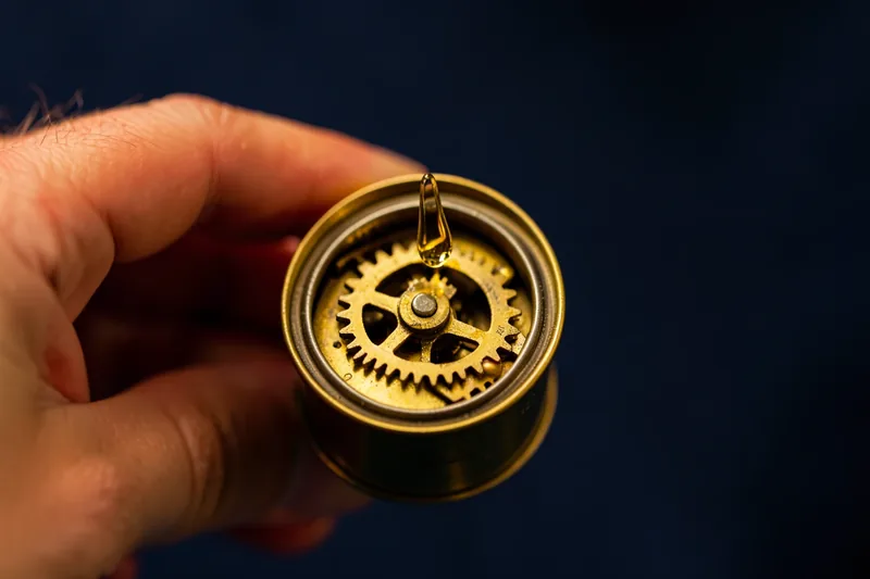 A drop of oil falling onto clean brass clockwork gears